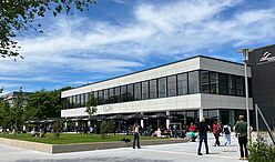 Mensa CGiN außen, Südseite und belebte Terrasse Südseite der Mensa CGiN mit großer Terrasse