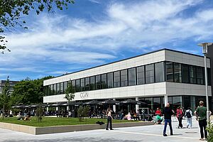 Mensa CGiN außen, Südseite und belebte Terrasse