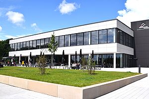 Südseite der Mensa CGiN mit Terrasse und Rasenflächen