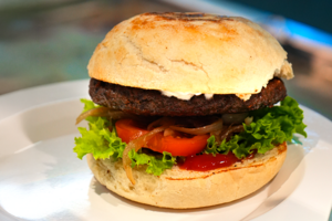 Bunter saftiger Burger auf einem Teller